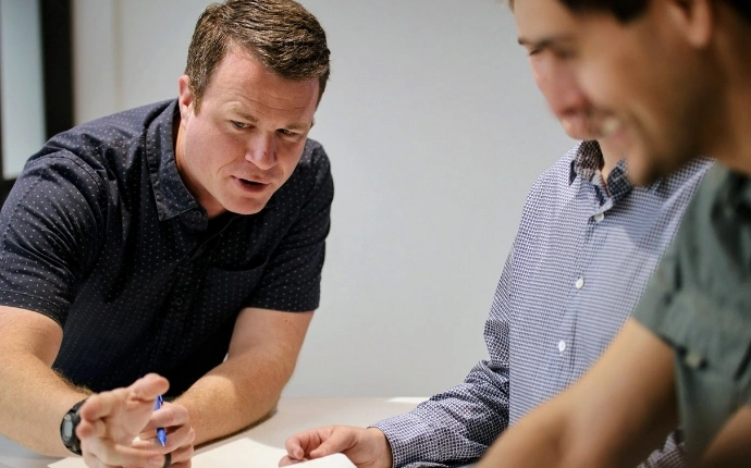 OuterBox link building strategist gesturing with a pen while explaining a campaign plan to a colleague