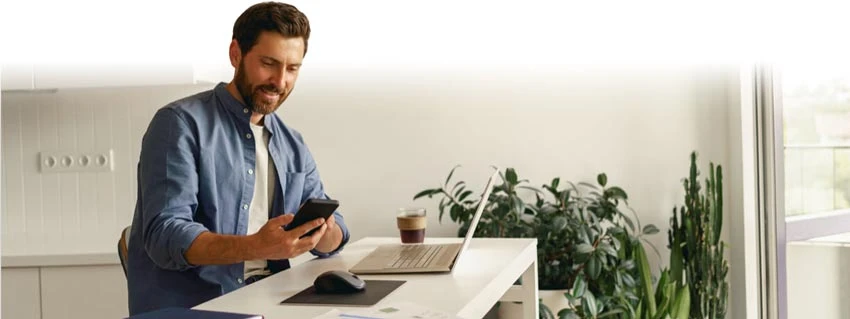 Person reviewing email marketing platforms on a laptop and smartphone