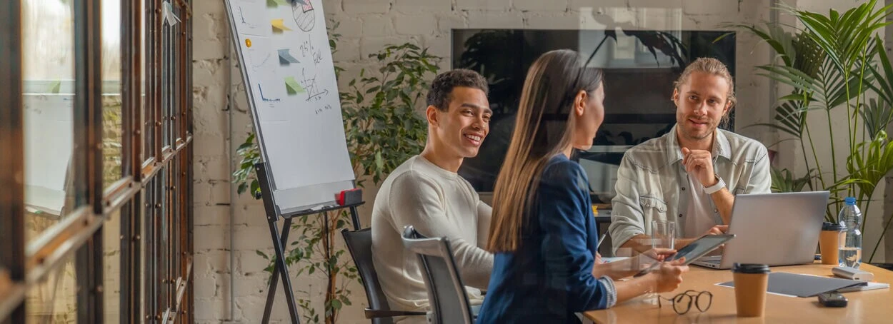Team comparing the best email marketing services beside a whiteboard